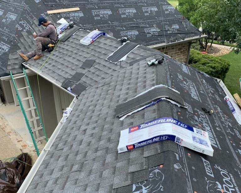 Austin roof installer adding shingles to a new roof in Austin.