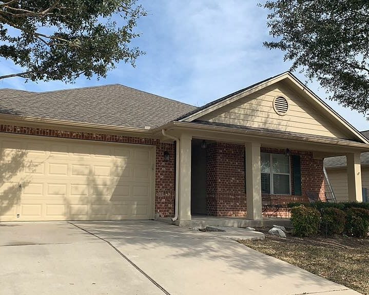 Red brick home with newly installed shingle roof.