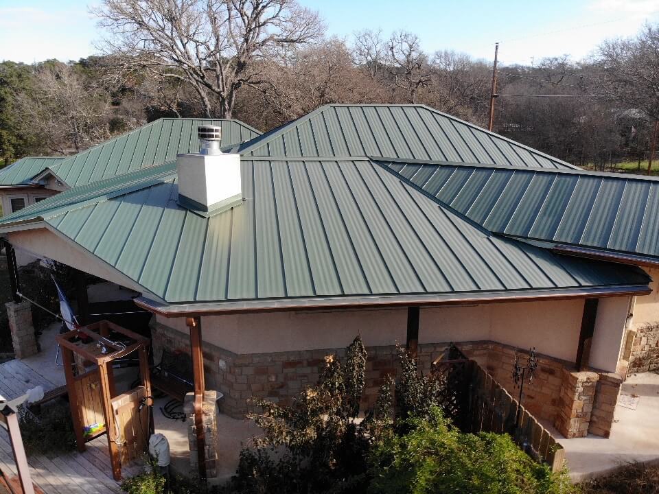 Backyard in Burnet, Texas with outdoor shower, jacuzzi, and a metal roof installed by A&W roofing company.