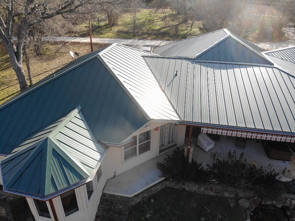 Green metal roof in Burnet with several levels and angles.