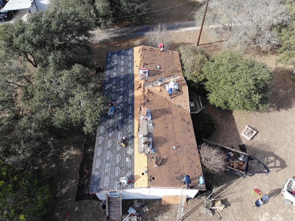 Roofing contractors nailing a new roof in place.
