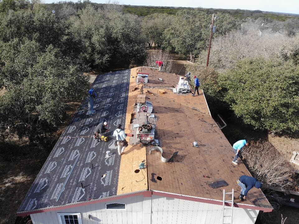 Roofing contractors installing a new roof on a home in Liberty Hill.