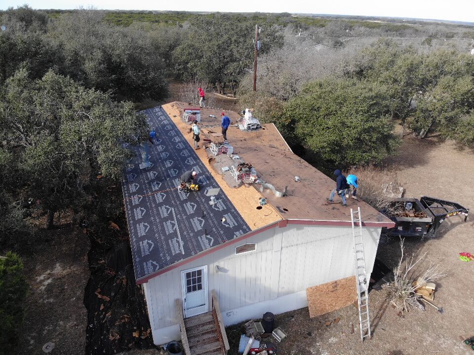 Roofing contractors removing the previous roof materials.