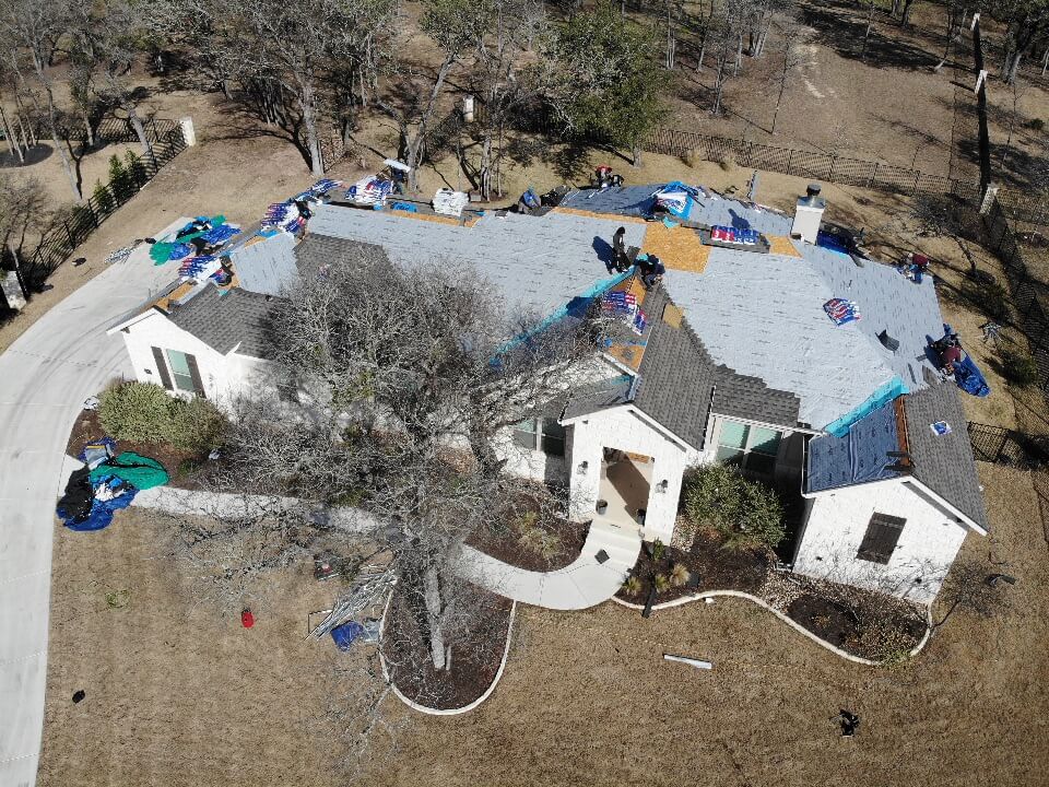 Liberty Hill roofing contractors laying out new shingles for a residential roofing project.
