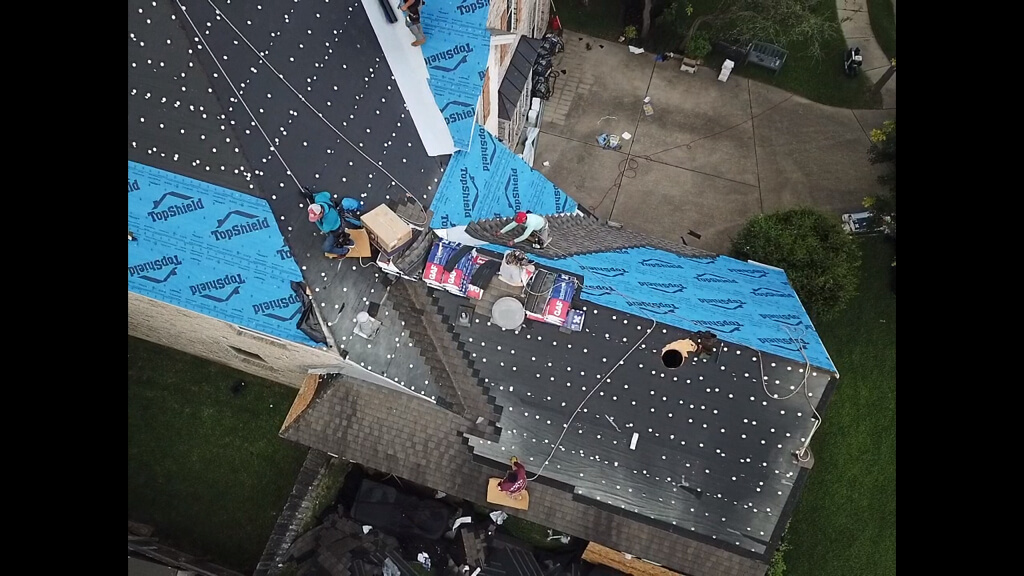 Construction workers installing shingles on a new roof in Pflugerville.