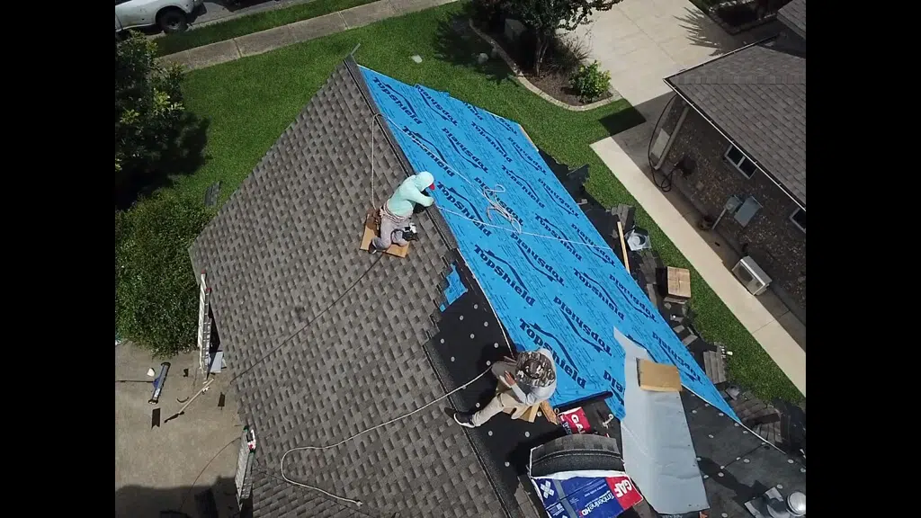 Two roof contractors working on roof replacement in Pflugerville.