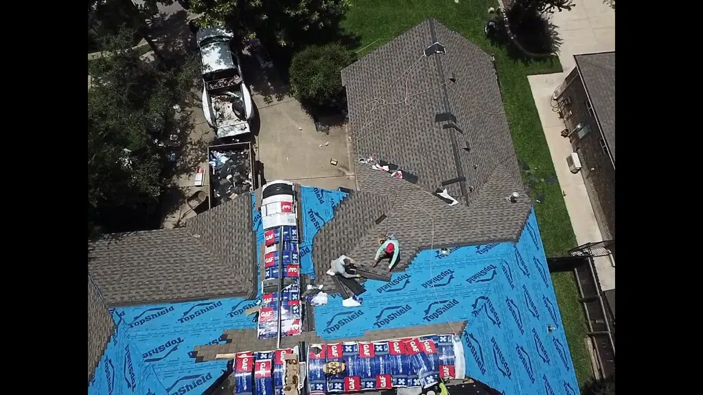Pflugerville roof replacement with roofing contractors nailing down new shingles.