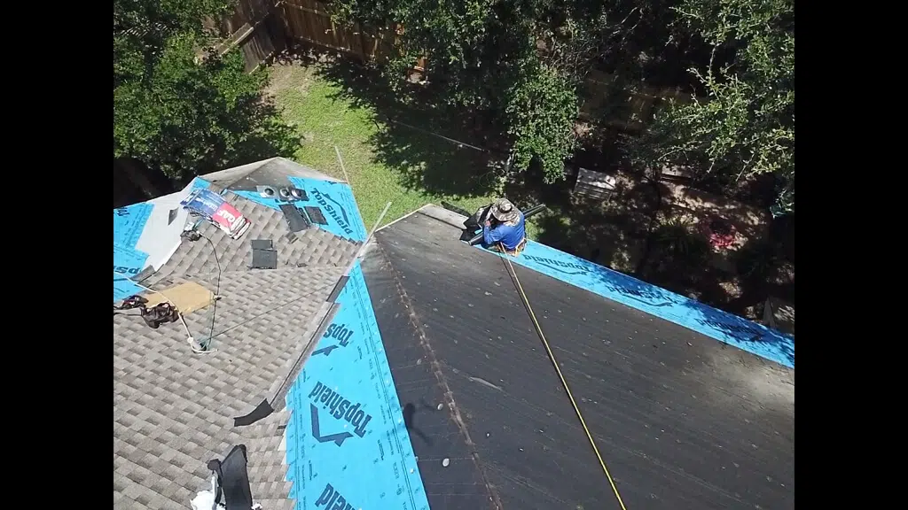 Pflugerville new roof installation with shingles being laid our by a roofing contractor.