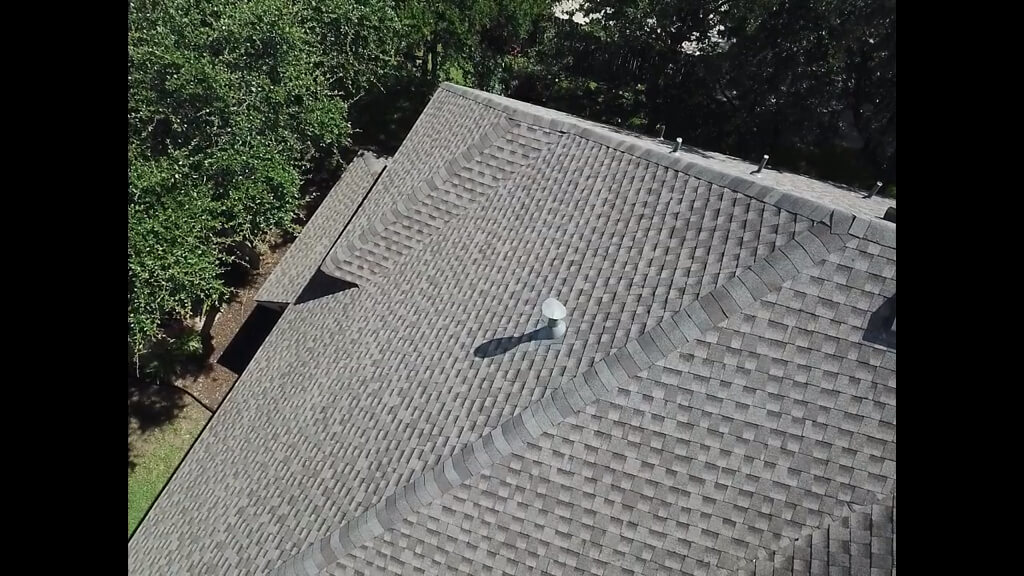 Pflugerville roofing on top of residential home with trees along the side of the home.