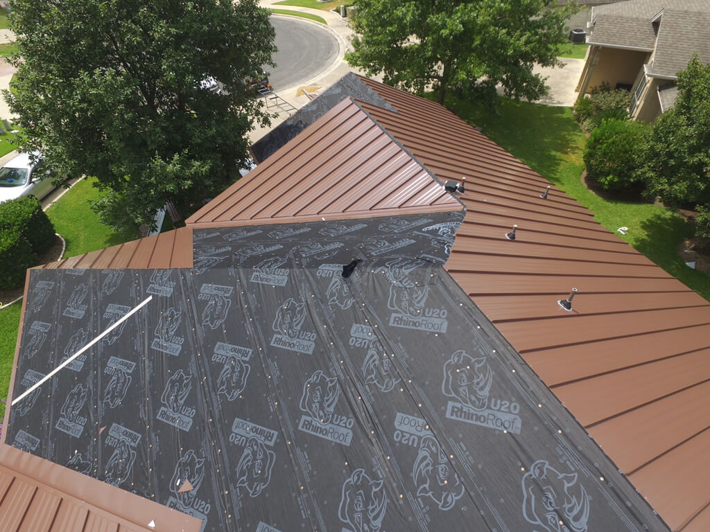 A&W roofing contractors in the process of installing a brown metal roof on a home in Georgetown.