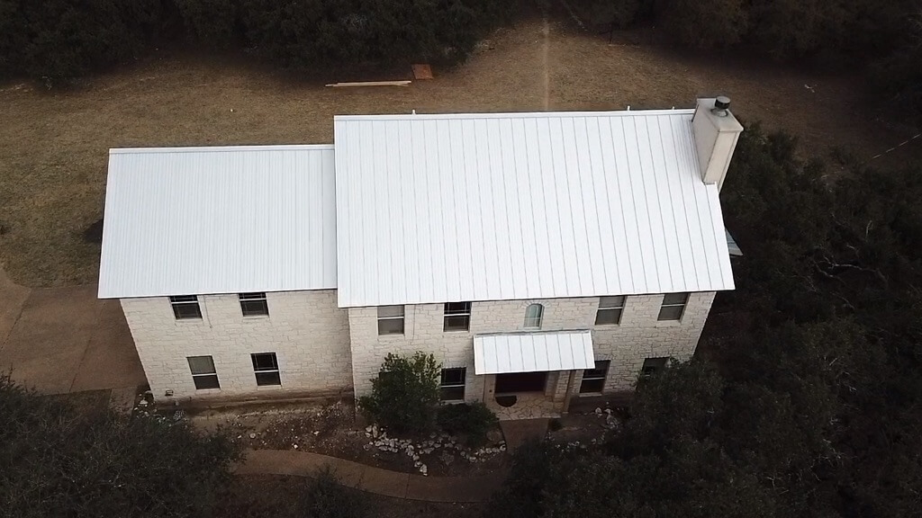 White metal roof in Liberty Hill home with large backyard and driveway.