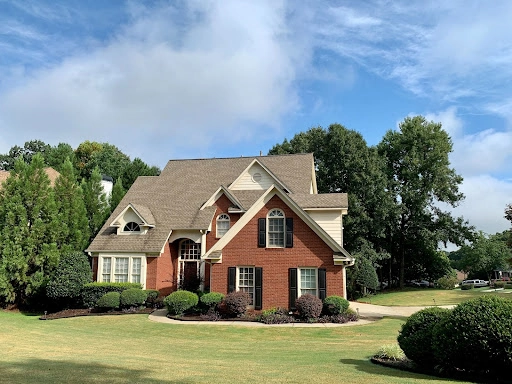 Red brick home with multi-level roof replacement in Austin.