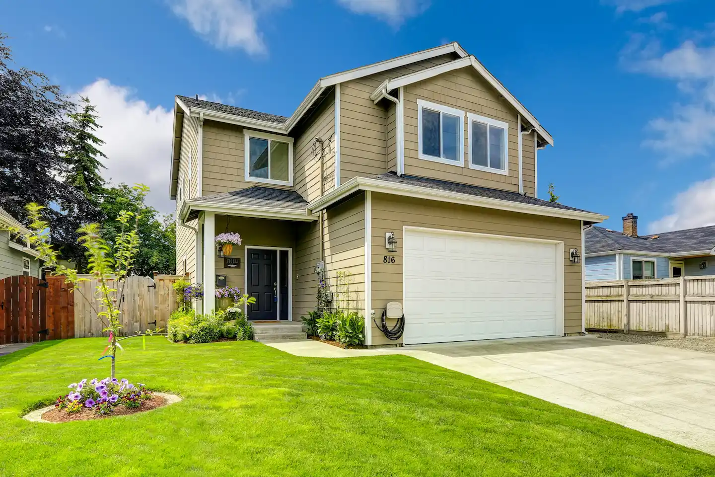 Two story home with tan colored siding.